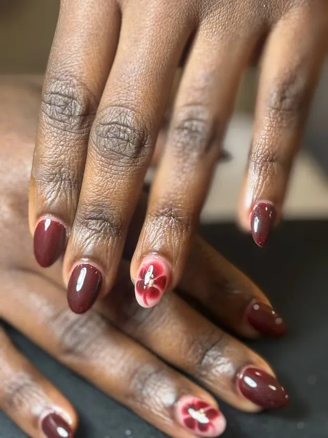 Deep burgundy nails with a hand-painted star